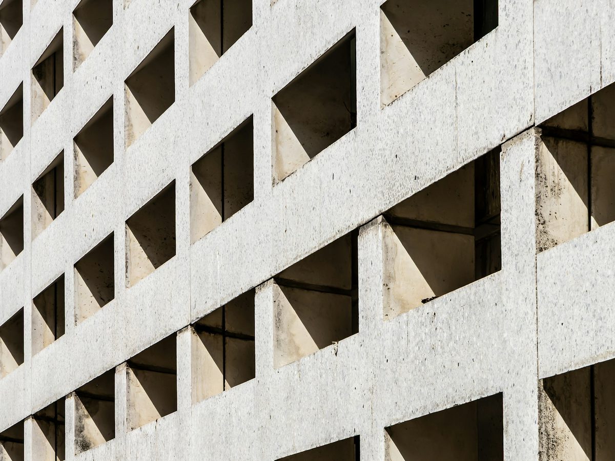 Concrete wall with square openings casting a pattern of shadows